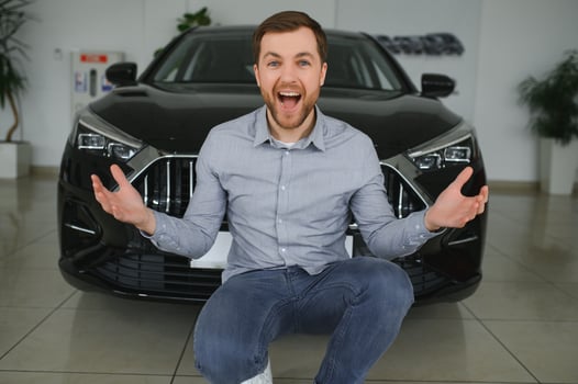 Young man is choosing a new vehicle in car dealership. photo