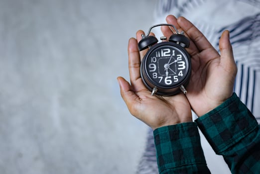Time management concept. Man hands holding Black retro alarm clock. Time to wake up for the morning routine photo