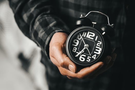 Time management concept. Man hands holding Black retro alarm clock. Time to wake up for the morning routine photo
