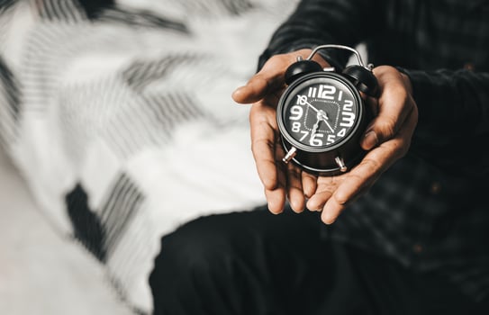 Time management concept. Man hands holding Black retro alarm clock. Time to wake up for the morning routine photo