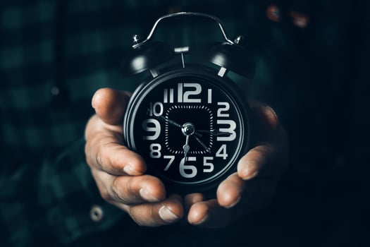 Time management concept. Man hands holding Black retro alarm clock. Time to wake up for the morning routine photo