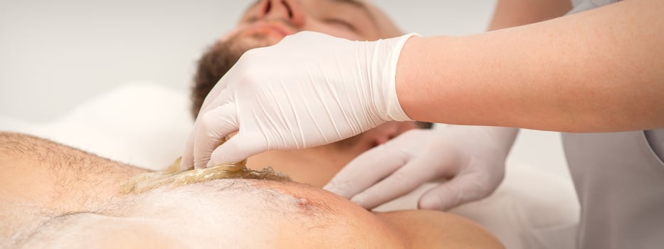 Epilation chest of a young male with the liquid wax paste in a beauty salon. photo