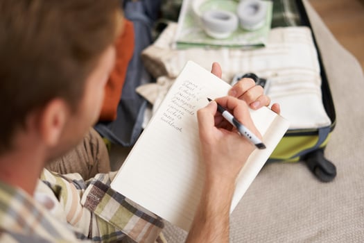 Close up portrait of man going through check-list, packing for holiday, looking at items he wants to bring on vacation photo