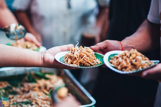 Volunteers are giving free food to help the hungry poor concept of food sharing photo