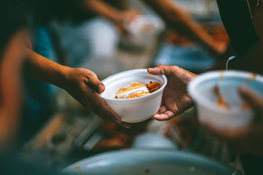 Volunteers are giving free food to help the hungry poor concept of food sharing photo