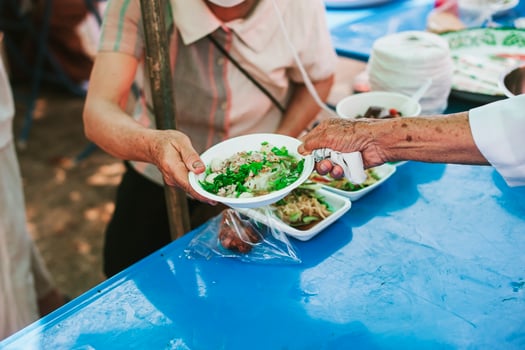 Volunteers are giving free food to help the hungry poor concept of food sharing photo