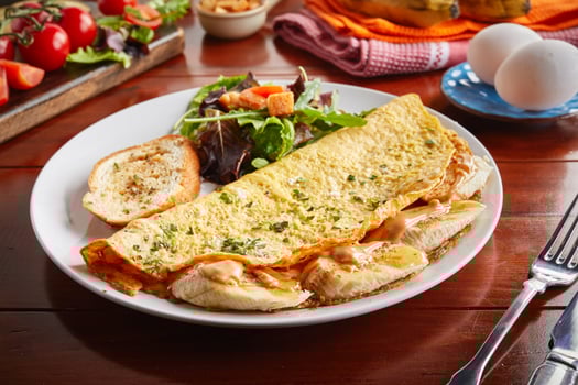 Banana peanut omelette roll served in a dish isolated on wooden background side view photo