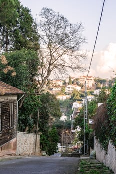 Istanbul, Turkey - January 06, 2023. A residential street with colorful houses. There are a few trees on either side of the street and the sky is blue with some clouds in the background. photo