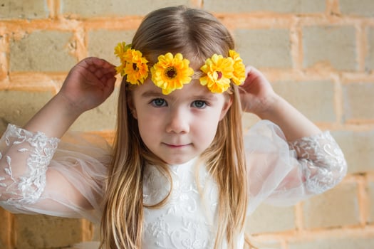 Portrait of a girl with long curly hair and a yellow flower crown in a natural setting. photo