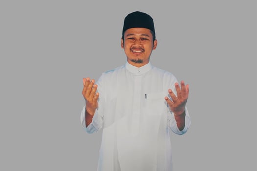Moslem Asian man smiling at the camera with arms open doing prayer gesture photo