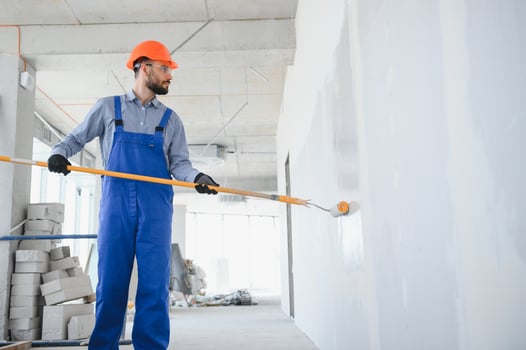 painter man painting the wall, with paint roller photo