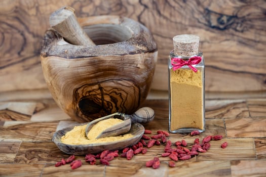 dried goji berries on olive wood photo