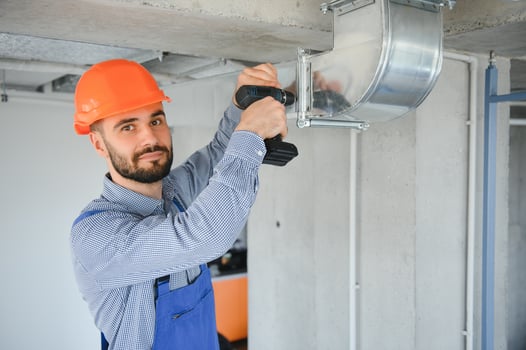 hvac worker install ducted pipe system for ventilation and air conditioning. copy space photo