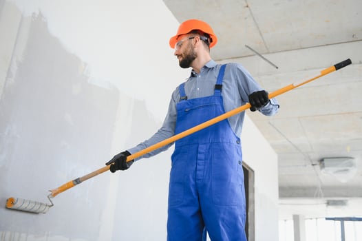 painter man painting the wall, with paint roller photo