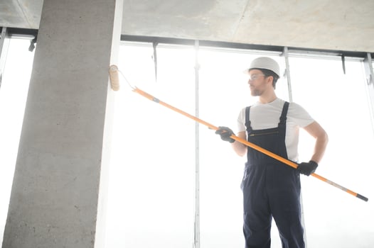 Painter man painting the wall, with paint roller. photo
