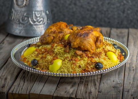 Chicken Machboos biryani served in dish side view on wooden table background photo