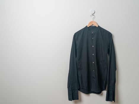 hanging shirt with wood hanger on wall photo