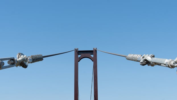 Large wire ropes that hold the bridge's steel structure. Background of clear sky. photo