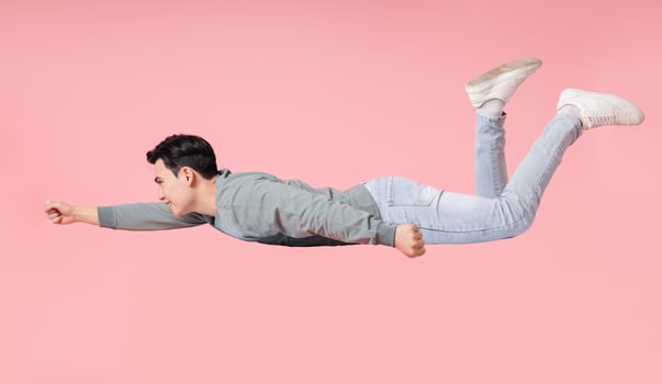 Photo of young Asian man flying on background