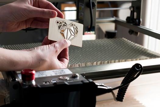 Laser engraving and cutting, woman holding an example of a cut out wooden heart photo