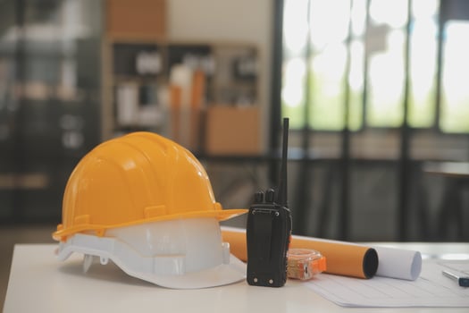 Male and Female Industrial Engineers in Hard Hats Discuss New Project while Using Laptop. They Make Showing Gestures.They Work in a Heavy Industry Manufacturing Factory. photo