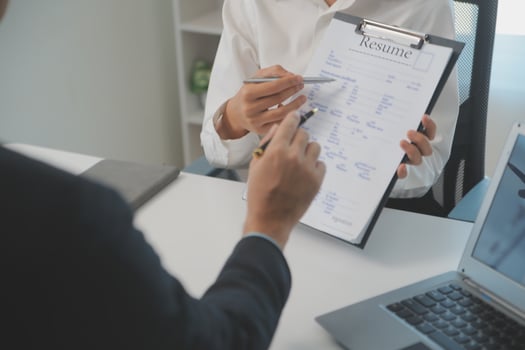 Close up view of job interview in office, focus on resume writing tips, employer reviewing good cv of prepared skilled applicant, recruiter considering application, hr manager making hiring decision photo