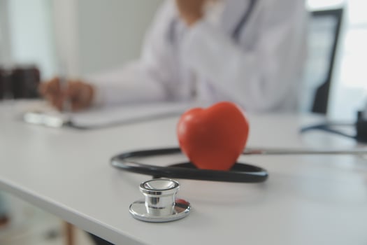 Hands of doctor woman holding red heart, showing symbol of love, human support to patient, promoting medical insurance, early checkup for healthcare, cardiologist help. Close up of object photo
