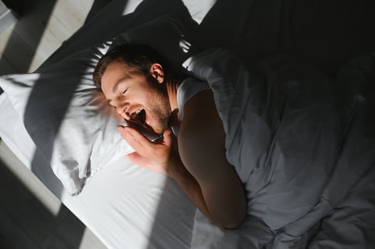 Happy young bearded man is relaxing on the bed at home photo