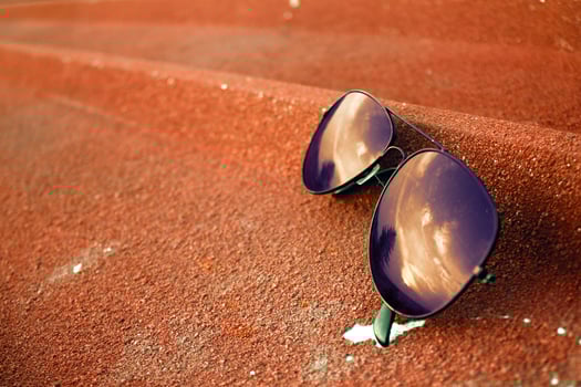 A pair of glasses placed on the roof of a house and reflecting a scene in the morning. photo