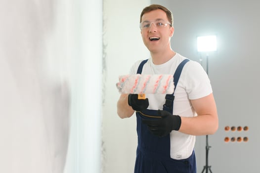 repair, building and home concept - close up of male in gloves holding painting roller photo