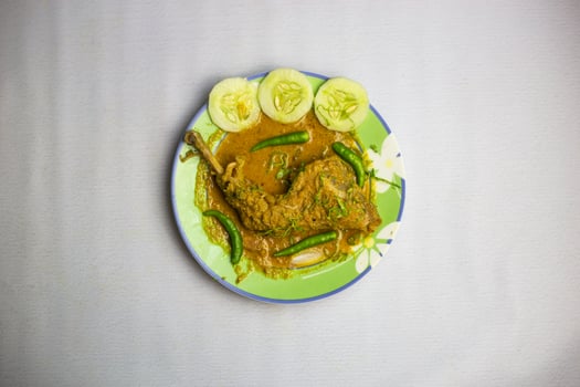bangladeshi Chicken Roast leg with gravy, coriander, cucumber and green chilli served in plate isolated on background top view of bangladeshi, indian and pakistani traditional spicy food photo