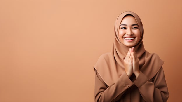 Southeast asian woman wearing scarf is praying and smiling on brown background photo