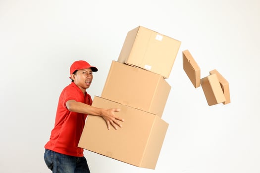 Asian Courier with Red Shirt Lifting Heavy Cardboard photo