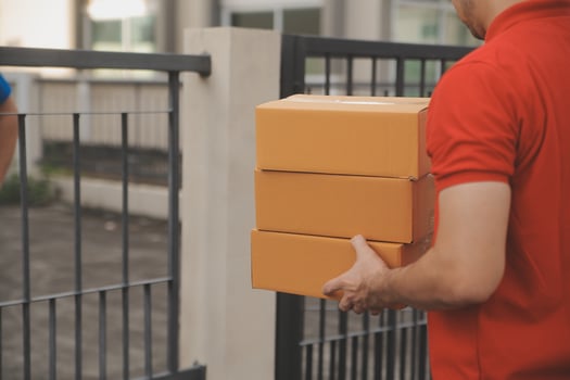 Asian delivery express courier young man use giving boxes to woman customer he wearing protective face mask at front home photo