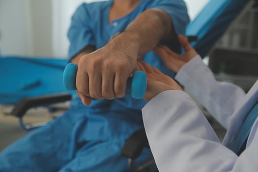 Physiotherapist man giving exercise with dumbbell treatment About Arm and Shoulder of athlete male patient Physical therapy concept photo