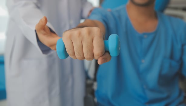 Physiotherapist man giving exercise with dumbbell treatment About Arm and Shoulder of athlete male patient Physical therapy concept photo
