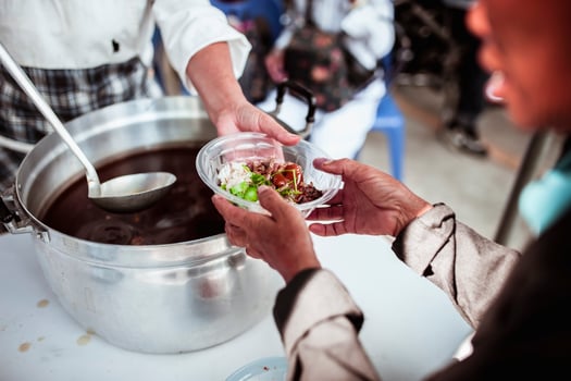 Feeding Concepts . Hand offered to donate food from a rich man Share. The concept of social sharing . Poor people receiving food from donations photo