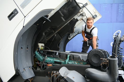 Professional truck mechanic working in vehicle repair service. photo