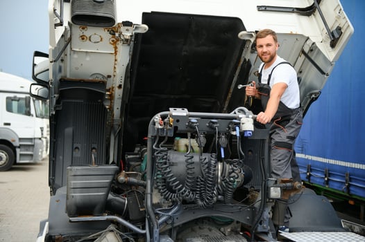 Man in uniform. Truck repair. Car malfunction photo
