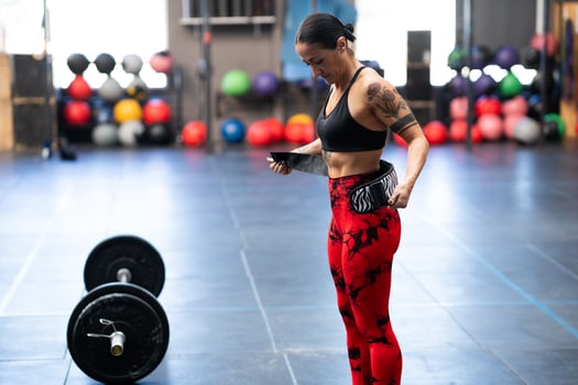 Woman tying a belt to prevent injures while weightlifting photo