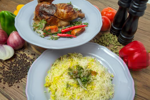 Half grilled chicken with pulao rice biryani, black pepper, bell peppers, tomato and onion served in dish isolated on table side view of arabic food photo