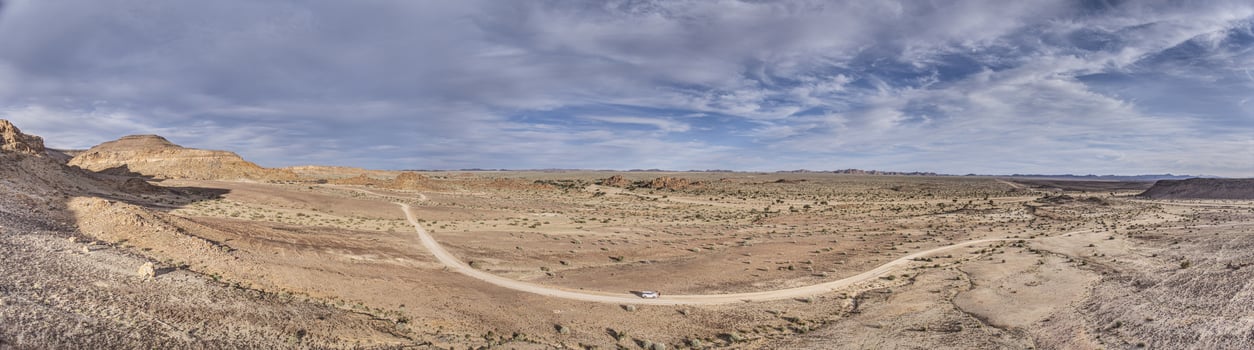 Panoramic picture over a gravel road near Fish River Canyon in southern Namibia under a blue sky photo