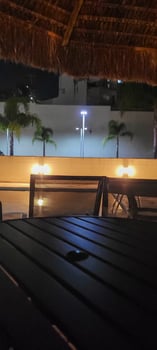 image of dark table in garden with pool at night photo