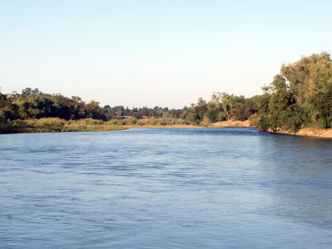 View down the river from bridge on summer morning photo
