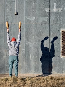 senior athletic male is exercising with wooden Indian clubs photo