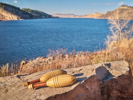 pair of Indian wooden clubs on a lake shore photo