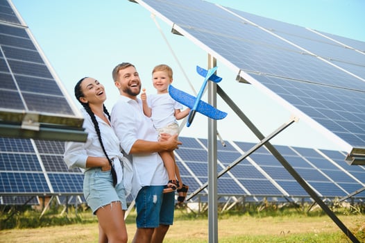 The concept of green energy. Happy family walking and having fun in solar panel field. Green energy. photo