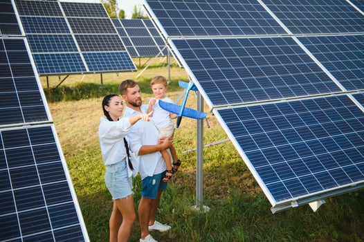 Happy family near solar panels. Alternative energy source photo