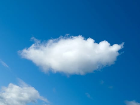 Single white fluffy cumulus cloud in the blue summer sky photo