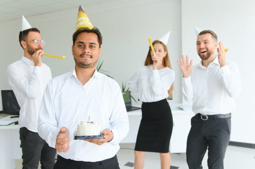 Surprise. Mixed race happy people celebrating a birthday of colleague in the modern office photo